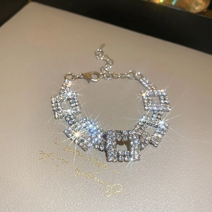 Detailed view of luxury silver layered necklace with square rhinestones on a display box