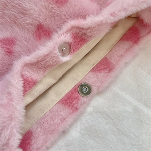Detail of pink leopard plush fabric and magnetic silver buckle on the bucket bag
