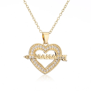 Close-up of gold plated heart MOM pendant with sparkling zircons on a white background