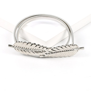 Detail of silver feather buckle on a stretchy metal spring belt for dresses