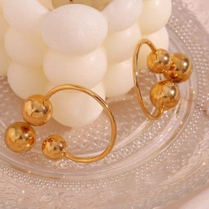 Detail of 18K gold plated stainless steel hoop earrings with triple ball charms