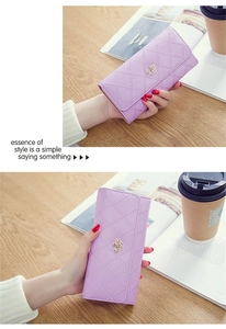 Detail view of lavender long wallet with quilted diamond pattern and golden crown charm
