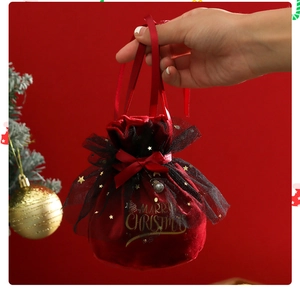 Detail view of red velvet Christmas gift pouch with gold stars and silver bell