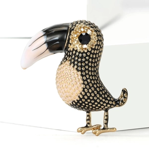 Macro detail of bird brooch showing gold-tone metal base and enamel textures
