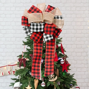 Plaid and burlap Christmas tree topper bow with festive ribbon on a decorated pine tree