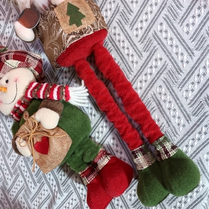Detailed top view of Christmas plush dolls featuring a snowman and elf on knit fabric