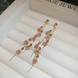 Boucles d'oreilles pendantes dorées avec pétales de fleurs roses et cristaux brillants
