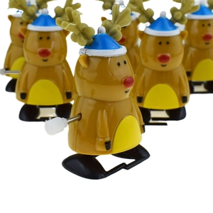 Jouet de renne de Noël mécanique marron avec un chapeau bleu et un nez rouge au premier plan