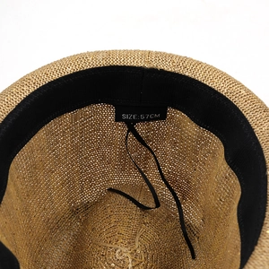 Close-up of straw hat interior showing woven texture, 57cm size tag, and sweatband