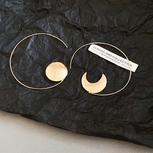Detailed close-up of asymmetric gold sun and moon geometric hoop earrings for women
