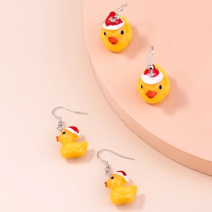 Detail of Christmas yellow duck earrings with red hats on pink display stands