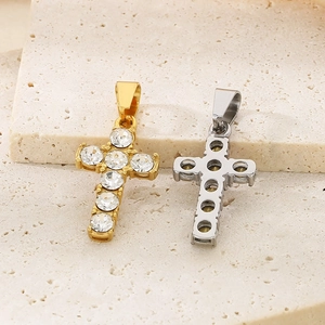 Detail of gold and silver cross pendants showing diamond inlay and hollow back structure