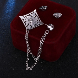 Vintage silver hollow square brooch with tassel chains and crystal accent on red velvet