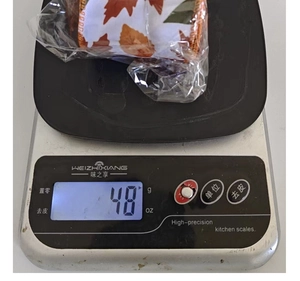 Gros plan montrant le poids de 48g d'un ruban d'automne à motif érable sur une balance