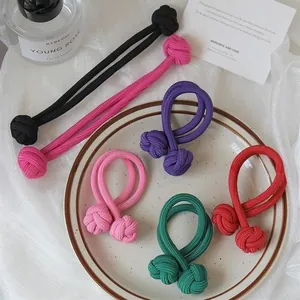 Close-up of high-elasticity braided hair ties in six vibrant colors displayed on a ceramic tray