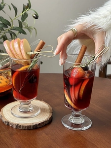 Close-up of elegant mulled wine glasses with fresh fruit slices and cinnamon sticks