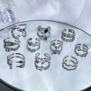 Set of 10 irregular silver open rings with heart, fox, and twisted textures on a mirror