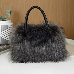 Detail of silver gray faux fur tote bag with black leather handles on white tabletop