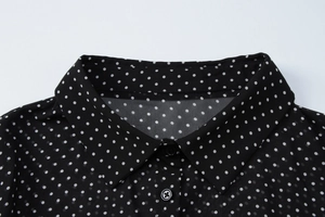 Dettaglio del colletto dell'abito in chiffon nero a pois bianchi con bottoni rotondi