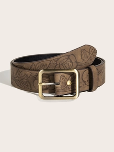 Detail of vintage brown textured leather belt with floral embossing and antique pin buckle