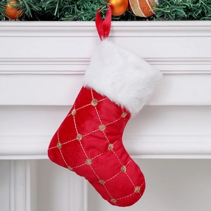 Detail of red sequined Christmas stocking with white fur cuff hanging on fireplace