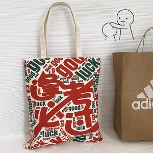 Detail of canvas tote bag with Good Luck print and reinforced stitching on handles