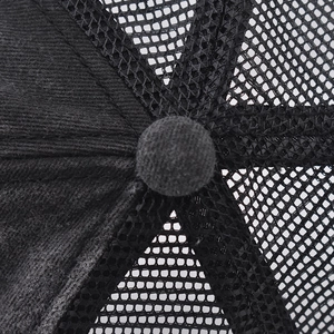 Close-up of the black trucker hat top button and breathable mesh fabric texture