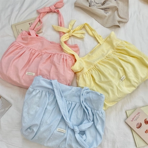 Detailed view of pleated cotton canvas tote bags in pink, yellow and blue with ribbon straps
