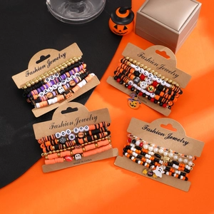 Detail of Halloween beaded bracelets with clay discs, pumpkin charms, and ghost pendants