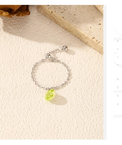 Detail of s925 silver chain ring with adjustable slider and green teardrop gemstone