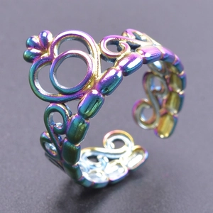 Macro detail of rainbow stainless steel adjustable ring with hollow hearts and swirls
