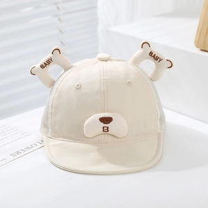 Detail showing breathable mesh fabric and bear ear embroidery on the cream baby hat