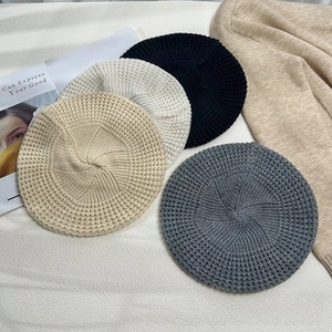 Detail of chunky knit beret showing textured honeycomb pattern in neutral colors