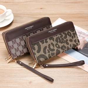 Long leopard and monogram print wallet with double zipper and wristlet on wooden desk