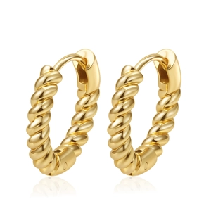 Macro detail of gold-plated twisted hoop earrings with a textured weave pattern