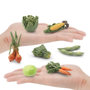 7-piece miniature vegetable set including corn and carrot, shown held in hand for scale