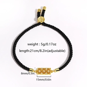 Macro view of adjustable black woven bracelet with gold cubic zirconia square pendant