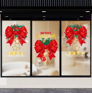 Close-up of red Christmas bow stickers with pine needles and gold baubles on glass