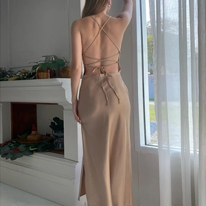 Détail de la robe en satin champagne montrant le dos nu croisé et la fente latérale