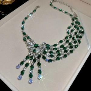 Detailed view of luxury multi-layer emerald and zircon bow necklace with tassels