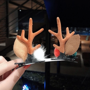 Detail of Christmas reindeer antler hair clips with felt leaves and fuzzy pom-poms