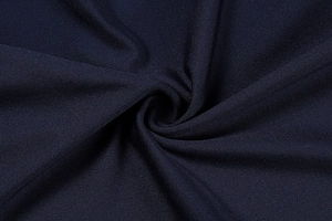 Macro detail of high-quality navy blue knitted fabric texture with elegant draping folds
