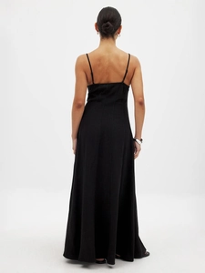 Detail of a minimalist black backless maxi dress with thin straps and a slim fit cut