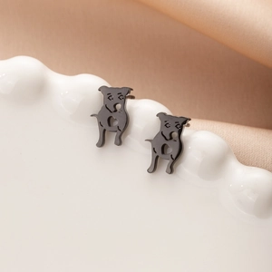 Close-up of black metal pug puppy stud earrings with hollow heart pattern details