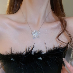 Detail of elegant silver flower pendant necklace with sparkling crystals worn by a model