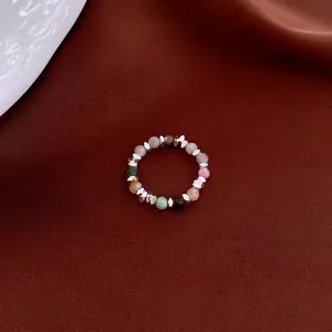 Retro multi-color gemstone beaded ring with silver spacers on deep red satin background