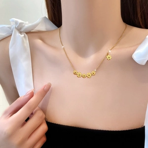 Minimalist gold titanium necklace featuring six daisy flowers on a delicate chain