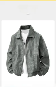 Detail of grey suede jacket featuring vintage embroidery and metallic zipper closure