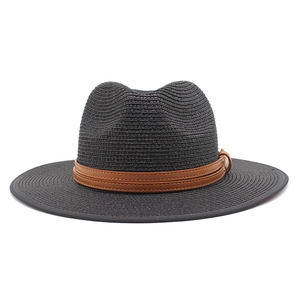 Détail d'un chapeau Panama en paille noire avec ruban en cuir marron et boucle métal