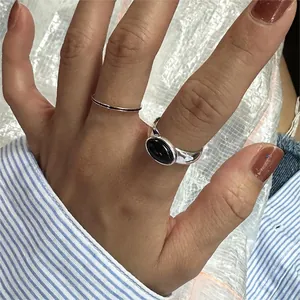 Detail of 925 sterling silver ring set with black agate stone for layered wearing style